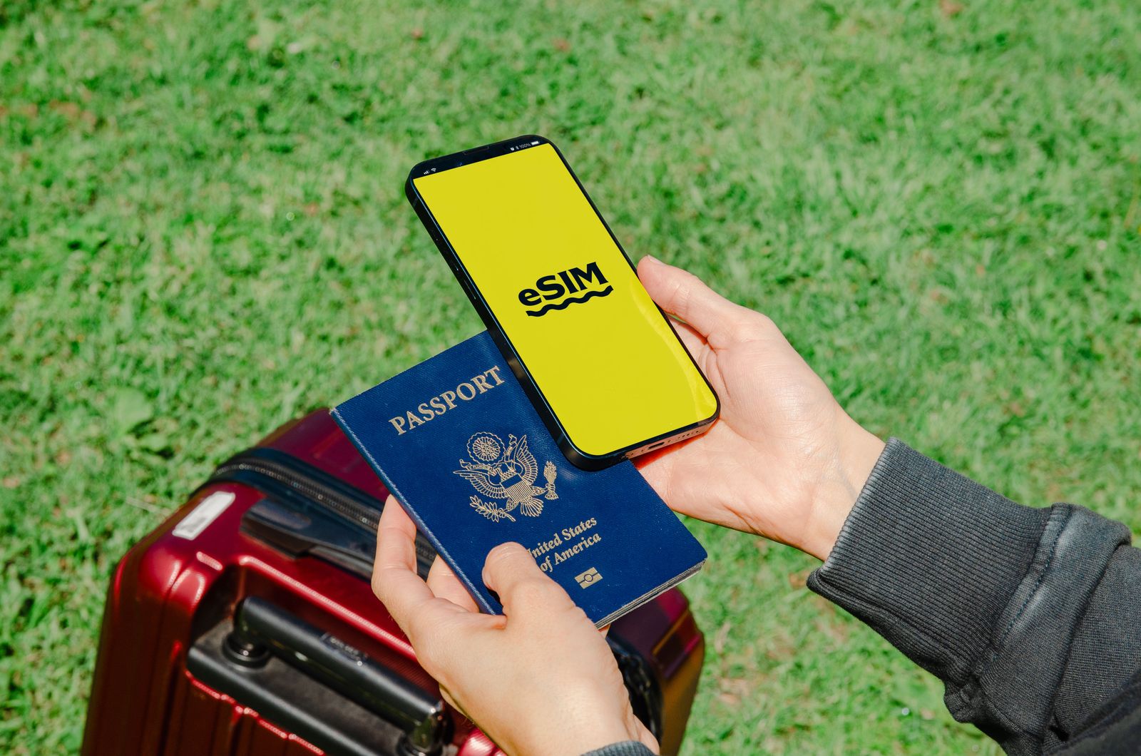 Hands holding a smartphone and passport, representing OTA booking and travel tech